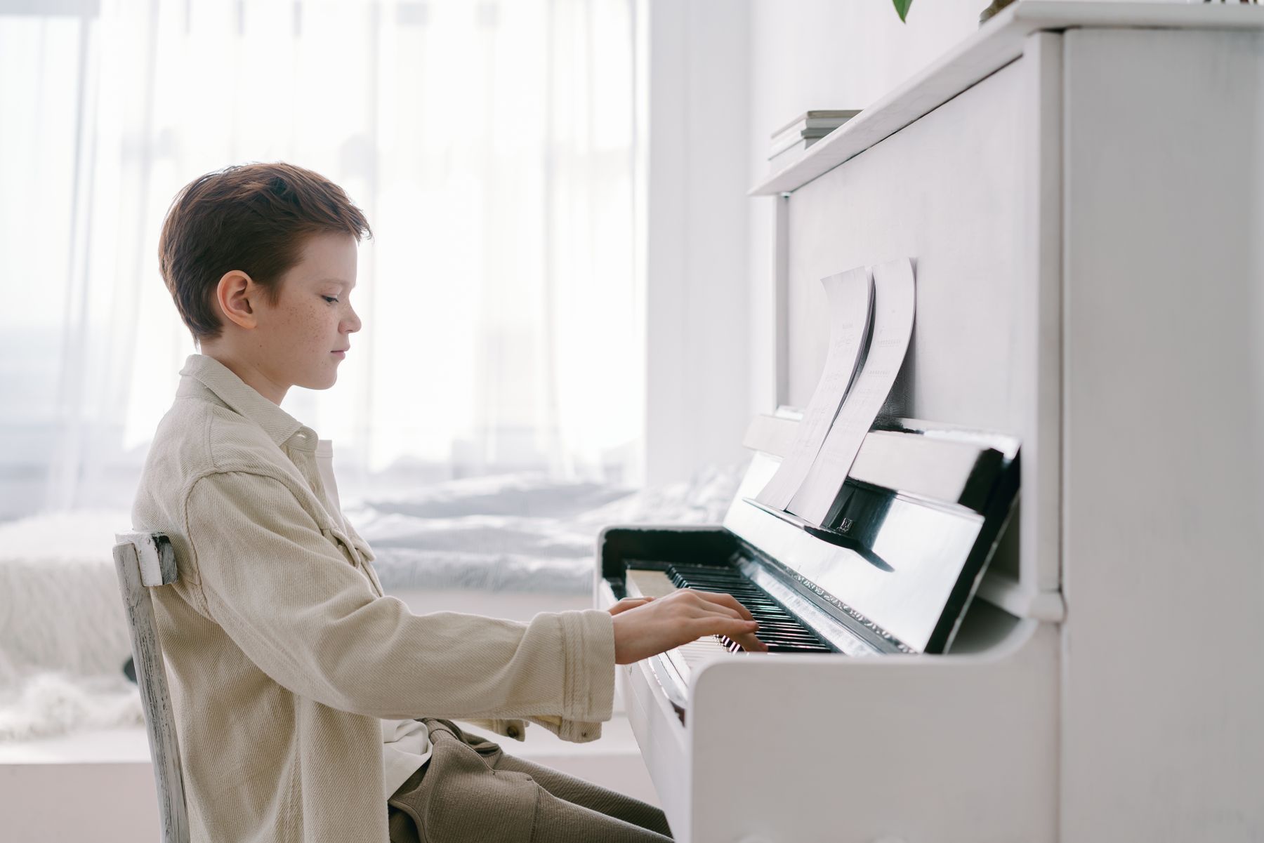A child practising at an upright piano.
