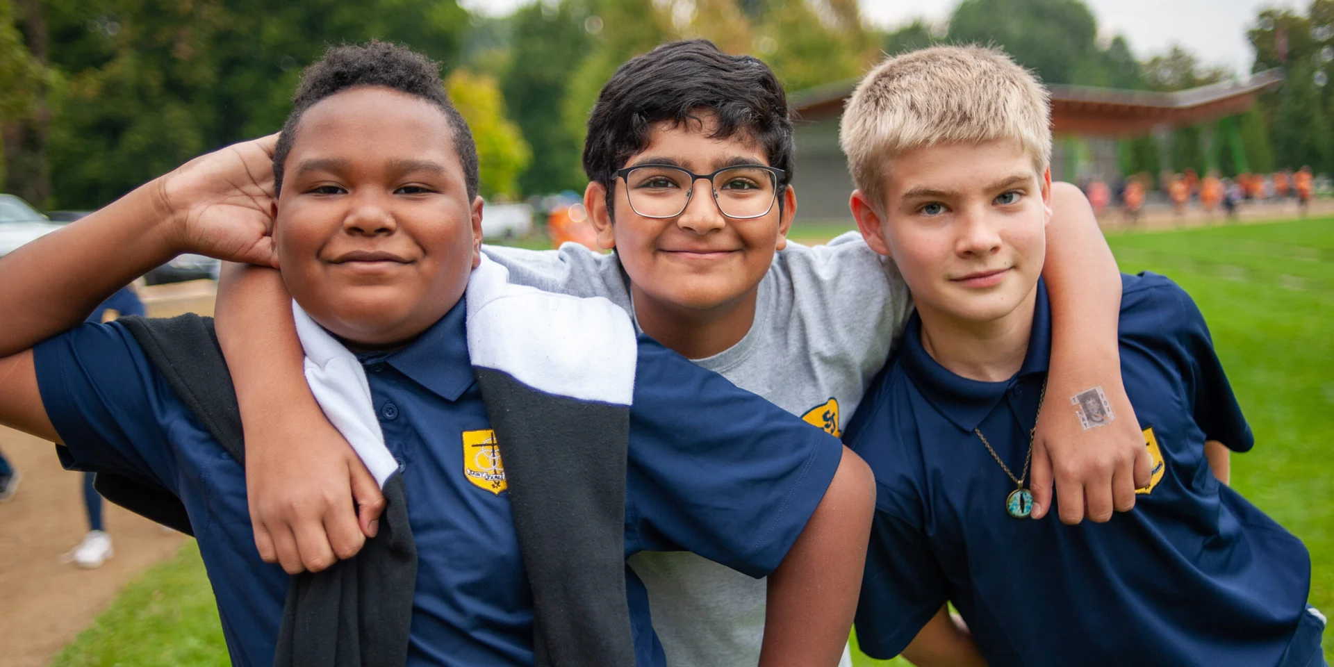 Three St. James pupils together outdoors in their school uniforms.